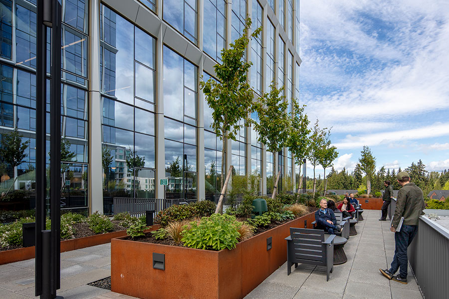 The terrace area of one of the 1001 Bellevue Office Buildings. People are sitting at tables and chairs.
